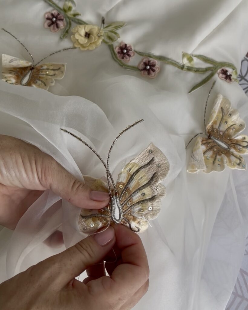 Hand sewing a butterfly detail onto Roxy’s heirloom wedding dress redesign